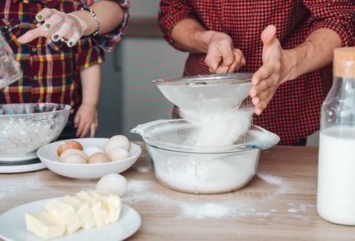 Dad sifts flour in the kitchen photo