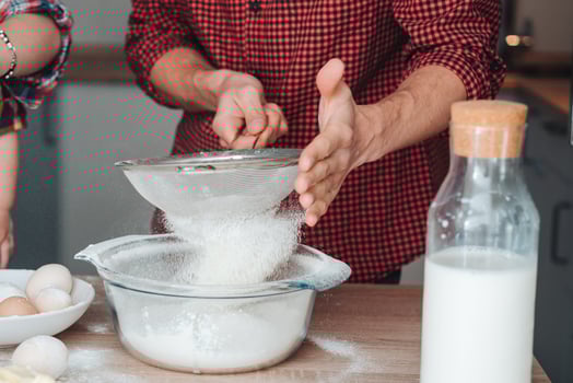 Dad sifts flour in the kitchen photo