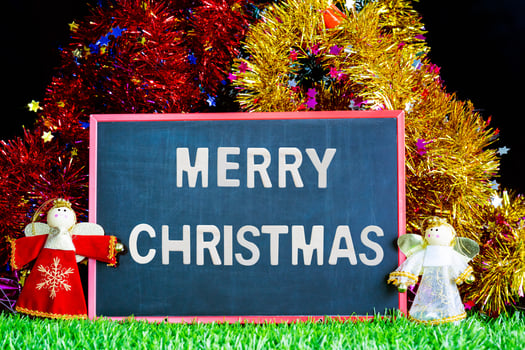 Doll snowman on green grass with chalkboard photo