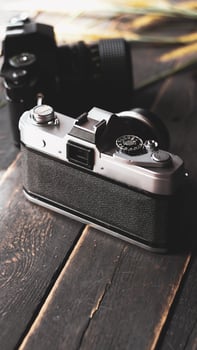 Negative film on a black wooden table and 2 vintage film cameras. photo