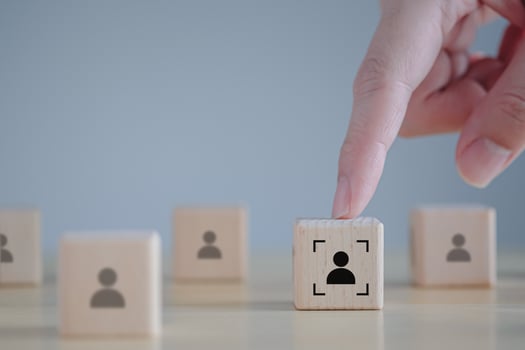 Business hiring and recruitment selection. Career opportunity. Human Resource Management. Hand touching focus human icon on wooden block. Choice of employee leader from the crowd. photo