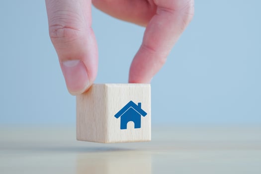 Real estate. House and property investment and asset management concept. Buy, Rent, Loan, Mortgage, House tax. Hand holding house icon on wooden block. photo