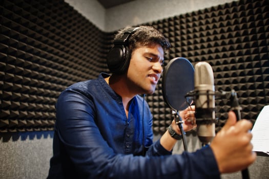 Young asian singer man with microphone recording song in record music studio. photo