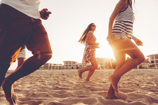 Young and full of energy. Group of young cheerful people running along the beach and looking happy photo