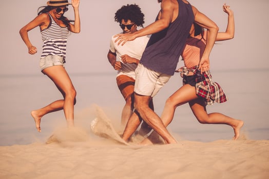 Fun in motion. Young cheerful people playing with soccer ball on the beach photo