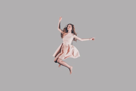 Beauty in motion. Studio shot of attractive young woman hovering in air photo