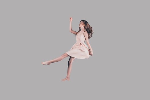 Her life in motion. Studio shot of attractive young woman hovering in air photo