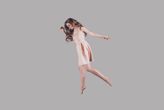 Flying high. Studio shot of attractive young woman hovering in air photo