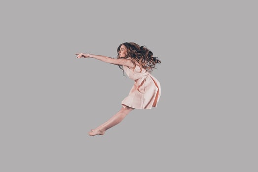 Free jumping. Studio shot of attractive young woman hovering in air photo