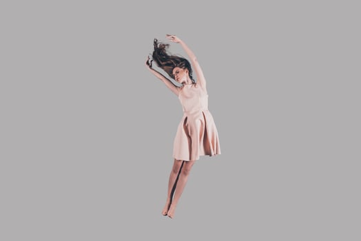 Jumping so high. Studio shot of attractive young woman hovering in air photo