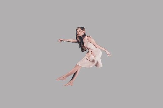 Hovering beauty. Studio shot of attractive young woman hovering in air photo
