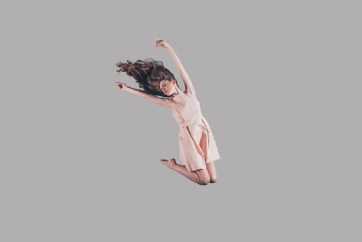 Jumping high. Studio shot of attractive young woman hovering in air photo