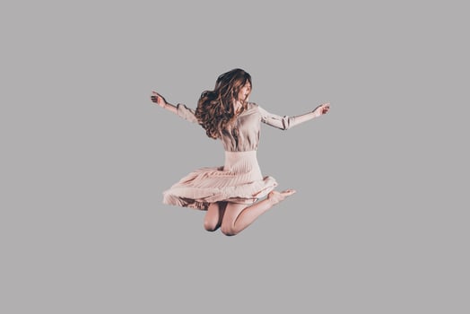 Flying like a bird. Studio shot of attractive young woman hovering in air photo