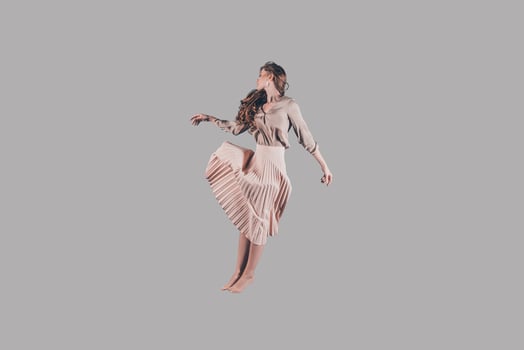 Levitation. Studio shot of attractive young woman in beautiful dress hovering in air photo