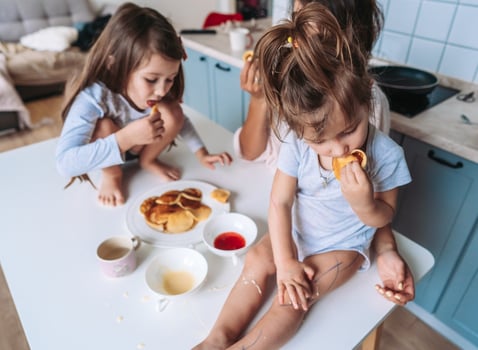 Mom and two daughters eat pancakes photo