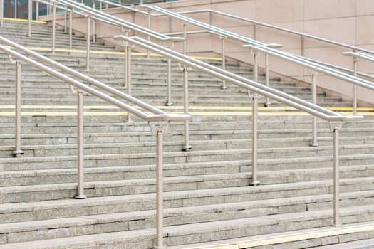view to outdoor steps with metal railing in center of leading to entrance into modern building photo