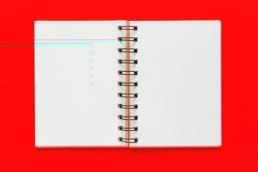 Clean spiral note book for notes and messages on red background. Minimal business flat lay photo