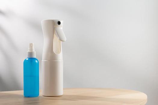 White alcohol spray bottle and a small blue alcohol spray bottle photo