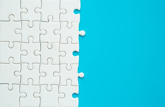 White part of jigsaw puzzle pieces on blue background. concepts of problem solving, business success, teamwork, Team playing jigsaw game incomplete, Texture photo with copy space for text