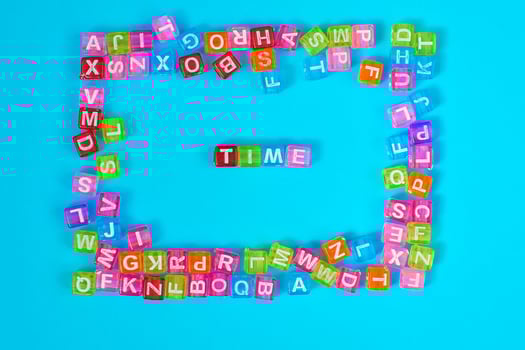 TIME inscription made of colorful cube beads with letters. Festive blue background concept with copy space photo