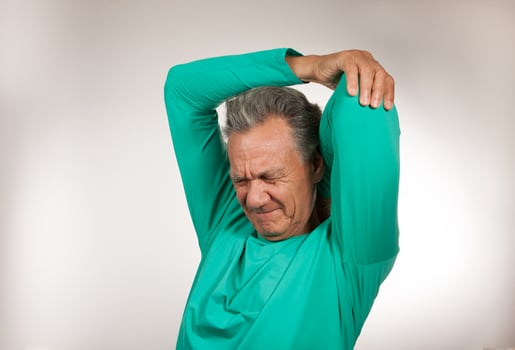 Mature Man 60plus doing back of the neck stretches for back and neck pain photo