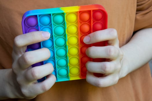 Hands hold a touch-sensitive fidget toy. Blue and Orange Funny Interactive Anti-stress Silicone Toys photo