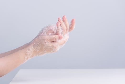 Washing hands. Asian young woman using liquid soap to wash hands, concept of hygiene to protective pandemic coronavirus isolated on gray white background, close up. photo