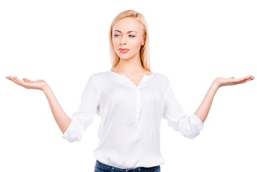 Ready to choose. Beautiful mature women stretching out arms and looking at one while standing against white background photo