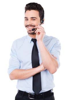 How may I help you Handsome young male operator adjusting his headset and smiling while standing against white background photo