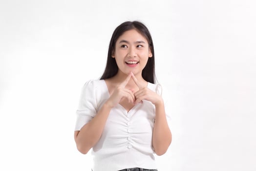 Asian beauty lady standing smiling in pink dress is looking at something while touching her face on a white background. photo