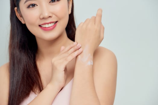 closeup of female hands applying hand cream photo