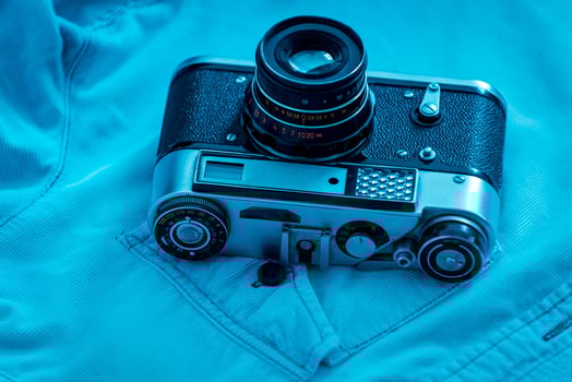 Retro styled camera. Close-up of retro camera laying on blue shirt photo