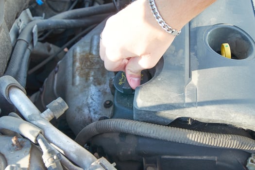 Mechanic checking and fixing a oil filler cap of a broken car in car on the road. photo