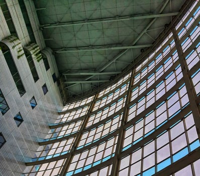 The inside of a tall building, lots of glass and very futuristic. photo