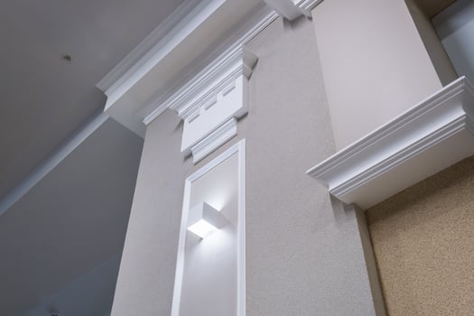 Detail of corner ceiling with intricate crown molding on column with spot light photo