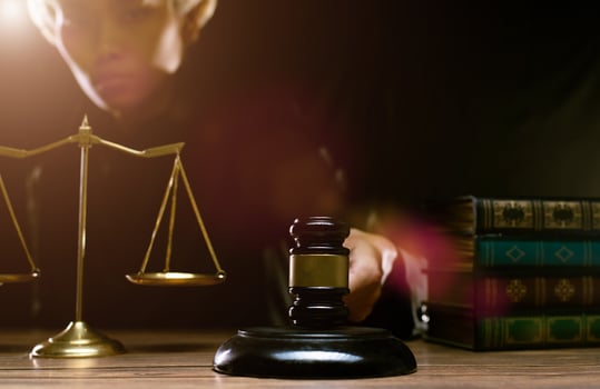 Justice Hammer and law concept. Judge in dark courtroom with the gavel brass scale text book hold hammer to make fair legal work on criminal guilty as professional authority judicial decision photo