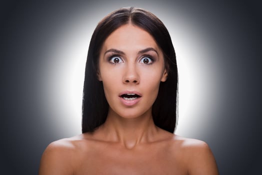 No way Portrait of surprised young shirtless woman looking at camera and keeping mouth open while standing against grey background photo