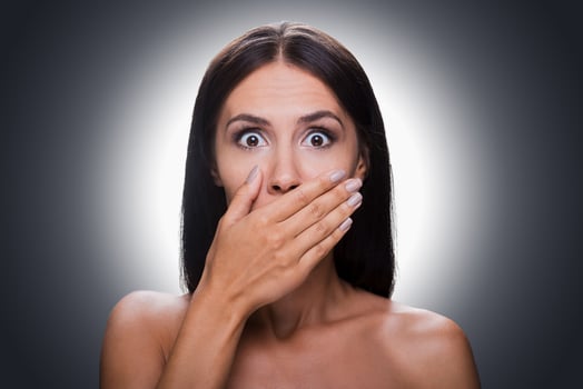 No more word Portrait of shocked young shirtless woman looking at camera and covering mouth by hand while standing against grey background photo