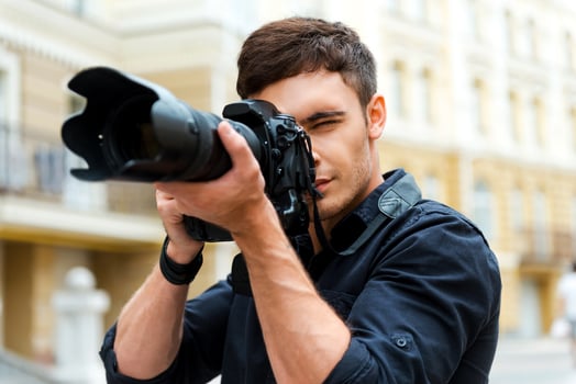 Photography is my passion. Confident young man photographing something while standing outdoors photo
