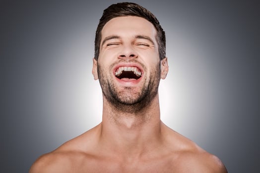 True happiness. Portrait of handsome young shirtless man keeping eyes closed and smiling while standing against grey background photo