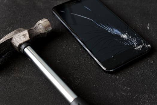 Cell phone with the screen broken by a hammer. close up photo