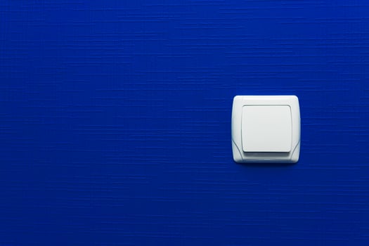 Light switch on blue wall background. Interior design. Minimal style. photo