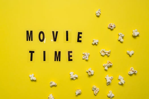Movie Time text lettering with scattered salty popcorn on yellow background. photo
