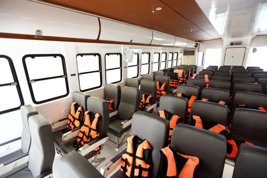 Many Seats row inside luxury cruise ferry with orange life vest jackets for Tourist to use to swim in Ocean sea and snorkeling underwater trip and safety first during transport photo