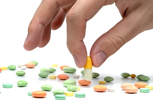 Hand holding capsule pill isolated on white background photo