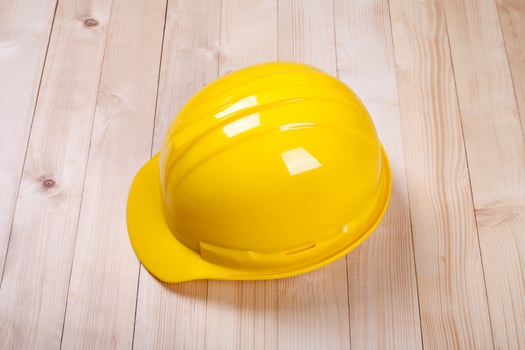 yellow hardhat architect on brown wood background photo