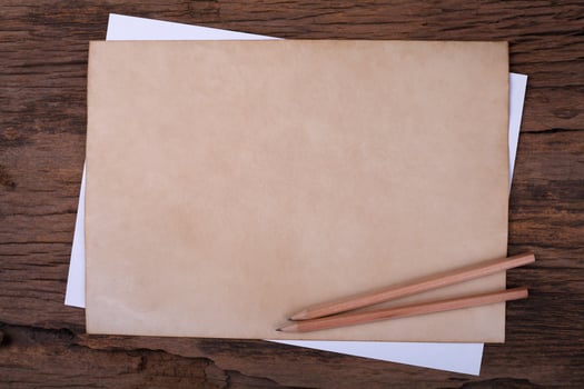 Old paper with  pencil on wooden table photo