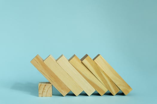 Wooden blocks on blue background. domino effect in business concept. photo
