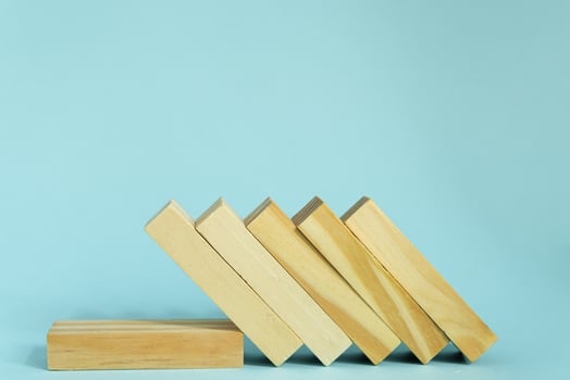 Wooden blocks on blue background. domino effect in business concept. photo