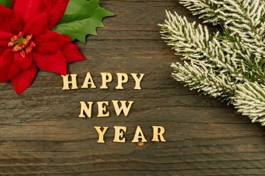 Happy New year 2021 celebration. Wooden text and poinsettia on wooden background. Flat lay. photo